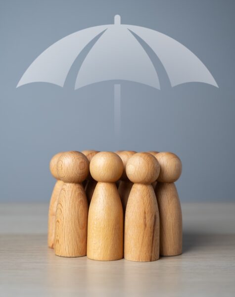 A group of people and an umbrella above. The concept of insurance and social protection. Life insurance. Customer care. Human resources. A group of people and an umbrella above. The concept of insurance and social protection. Life insurance. Customer care. Human resources.