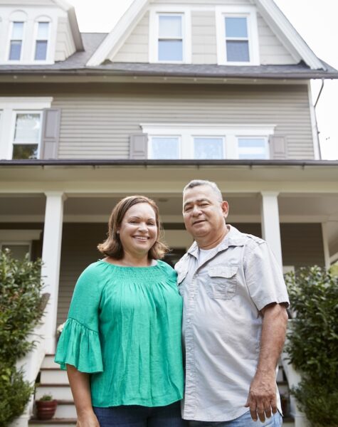 Portrait Of Smiling Senior Couple In Front Of Their Home Portrait Of Smiling Senior Couple In Front Of Their Home