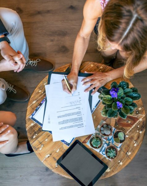 Top view of woman signing a document Top view of woman signing a document at an informal work meeting
